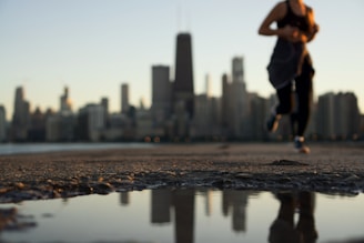 A person jogging early morning with a city skyline in the background.