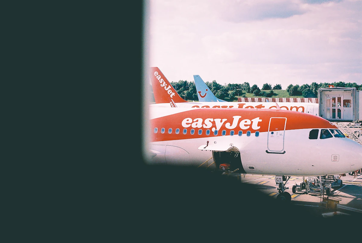 A white and orange easyJet aircraft on the airport apron