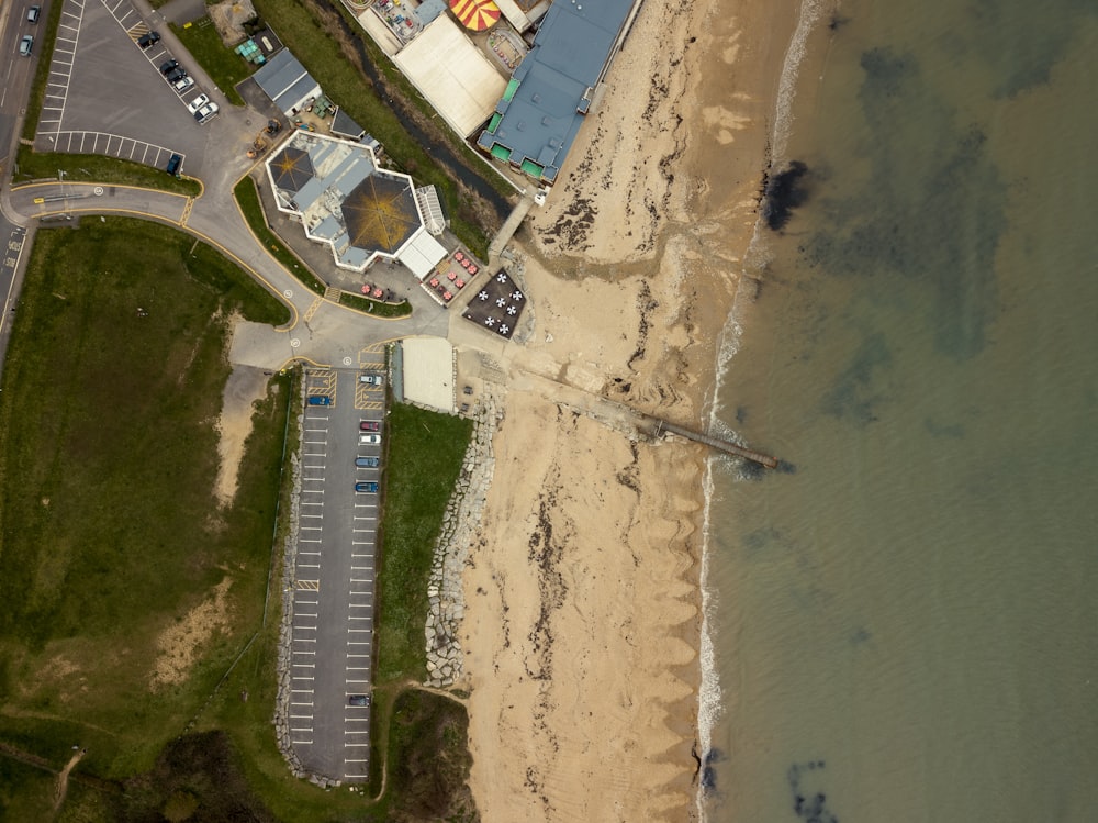 an aerial view of a parking lot next to a beach