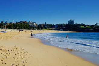 A sandy beach just steps away from the hotel, with gentle waves and a family enjoying the sun.