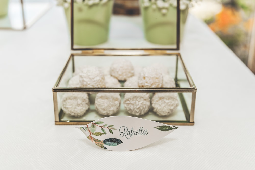 white and green Rafaellas printed decor near square gray metal framed case on top of table