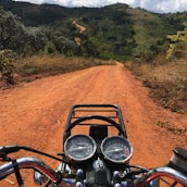 Close-up of a motorcycle handlebar with the Blue Ridge Mountains stretching out ahead.