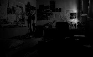 An intimate interior shot of a cluttered writer’s room, warm light spilling over scattered scripts and storyboards