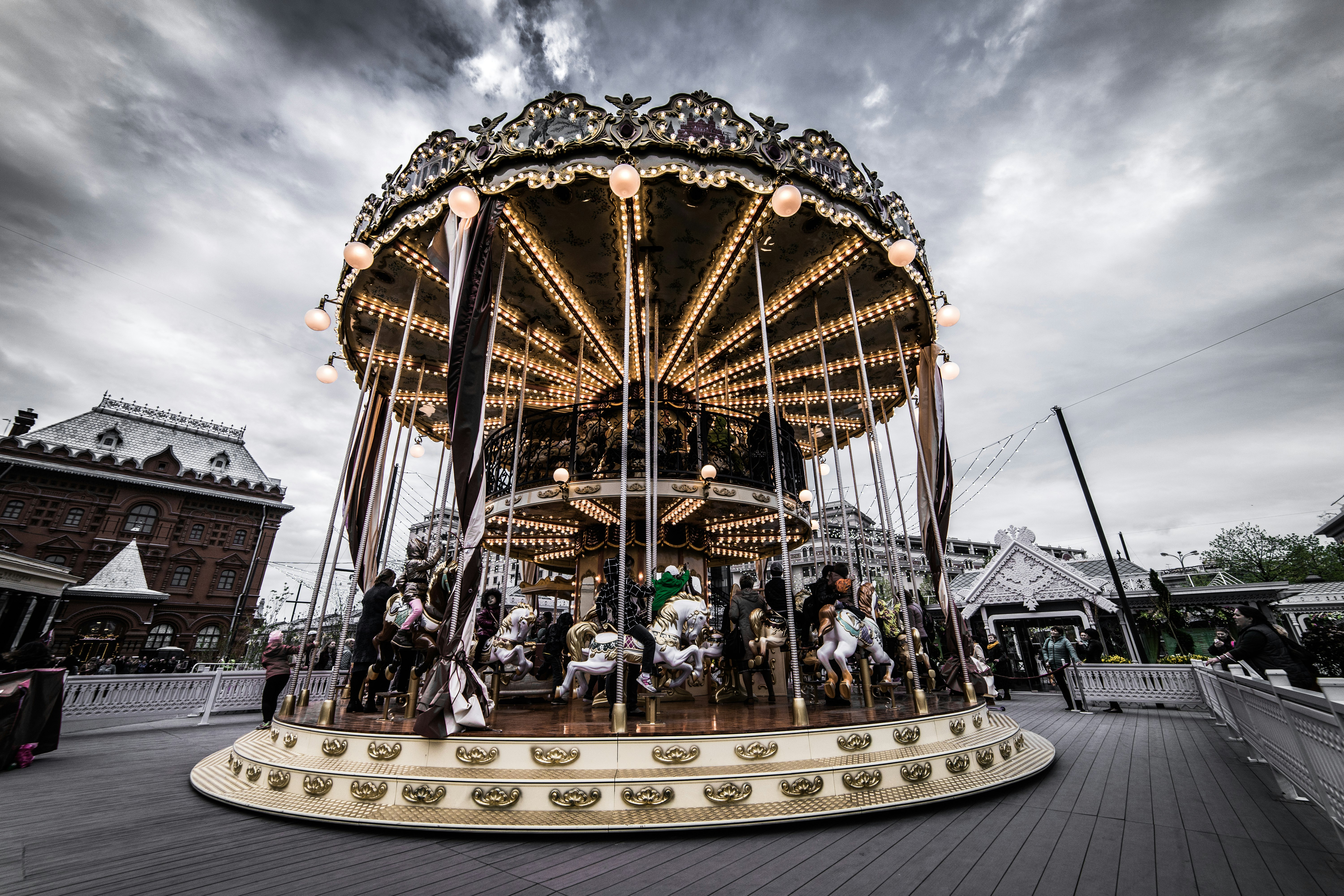 people riding carousel during daytime