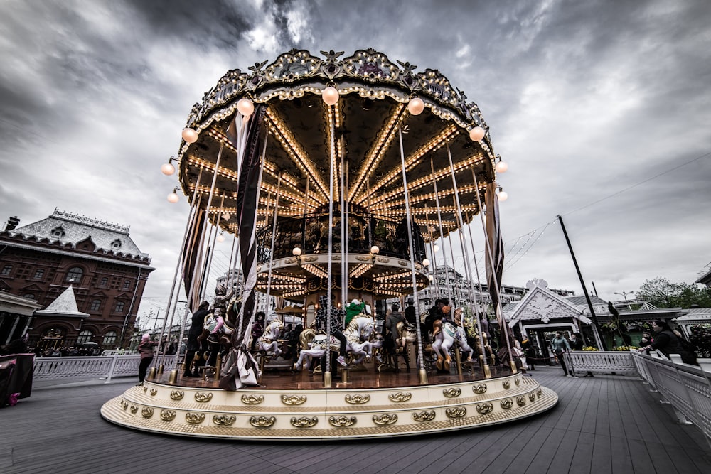 people riding carousel during daytime