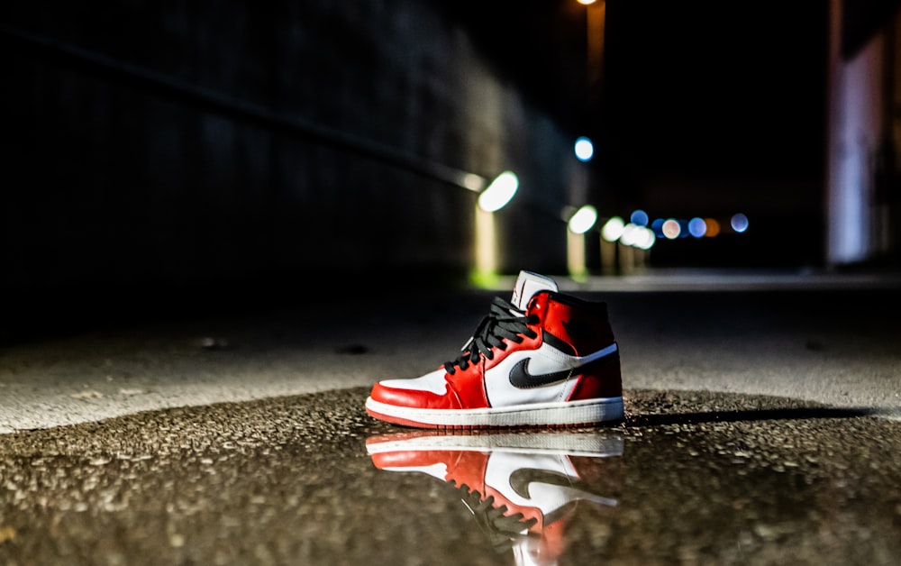 red and white Air Jordan 1 shoe on concrete floor