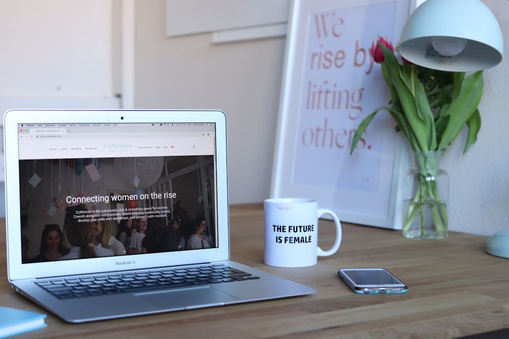 MacBook Air beside cup