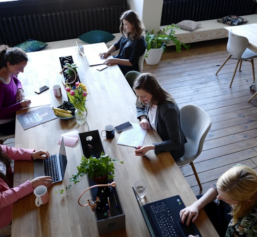 a group of people sitting around a wooden table