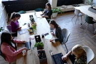 a group of people sitting around a wooden table