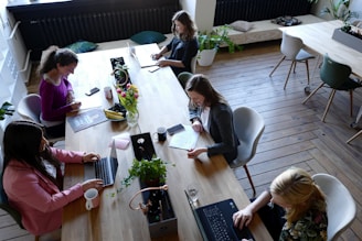 a group of people sitting around a wooden table