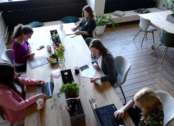 a group of people sitting around a wooden table