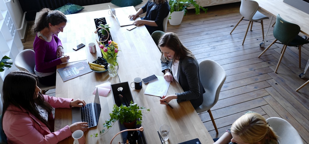 a group of people sitting around a wooden table