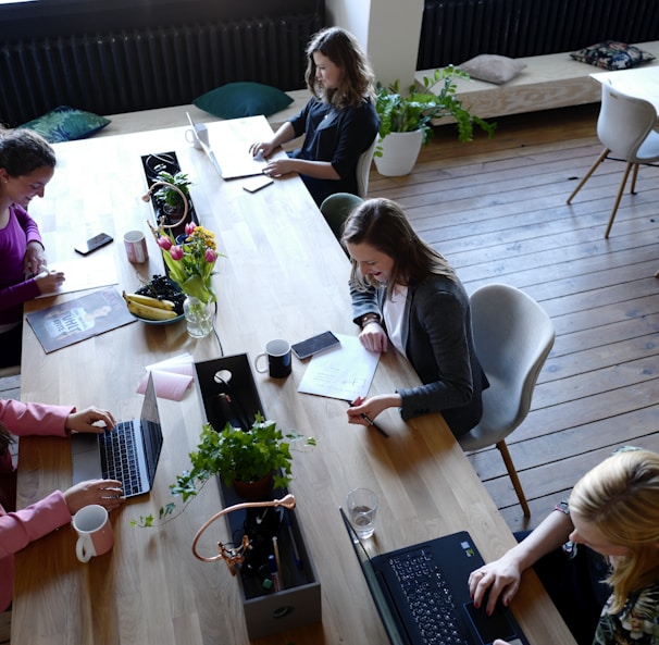 a group of people sitting around a wooden table