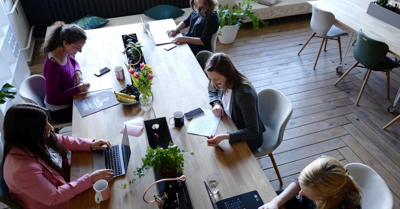 a group of people sitting around a wooden table