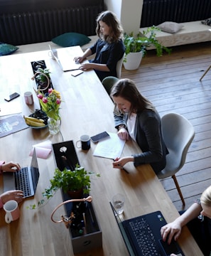 a group of people sitting around a wooden table