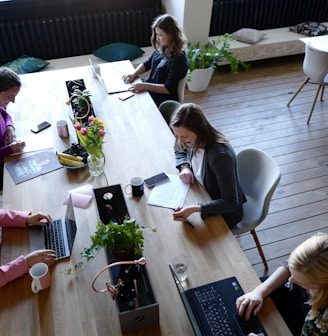 a group of people sitting around a wooden table