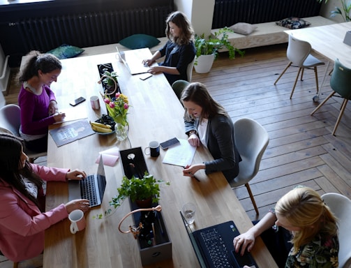 a group of people sitting around a wooden table