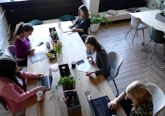 a group of people sitting around a wooden table