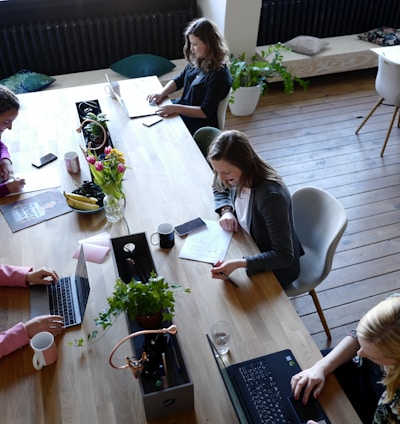 a group of people sitting around a wooden table