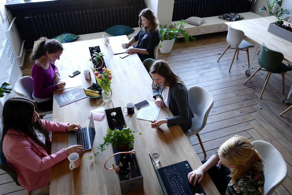 a group of people sitting around a wooden table