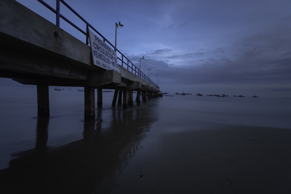 long walk bridge under grey cloudy sunset sky