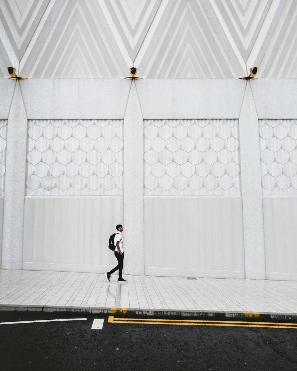 Hombre caminando sobre pavimento de hormigón blanco