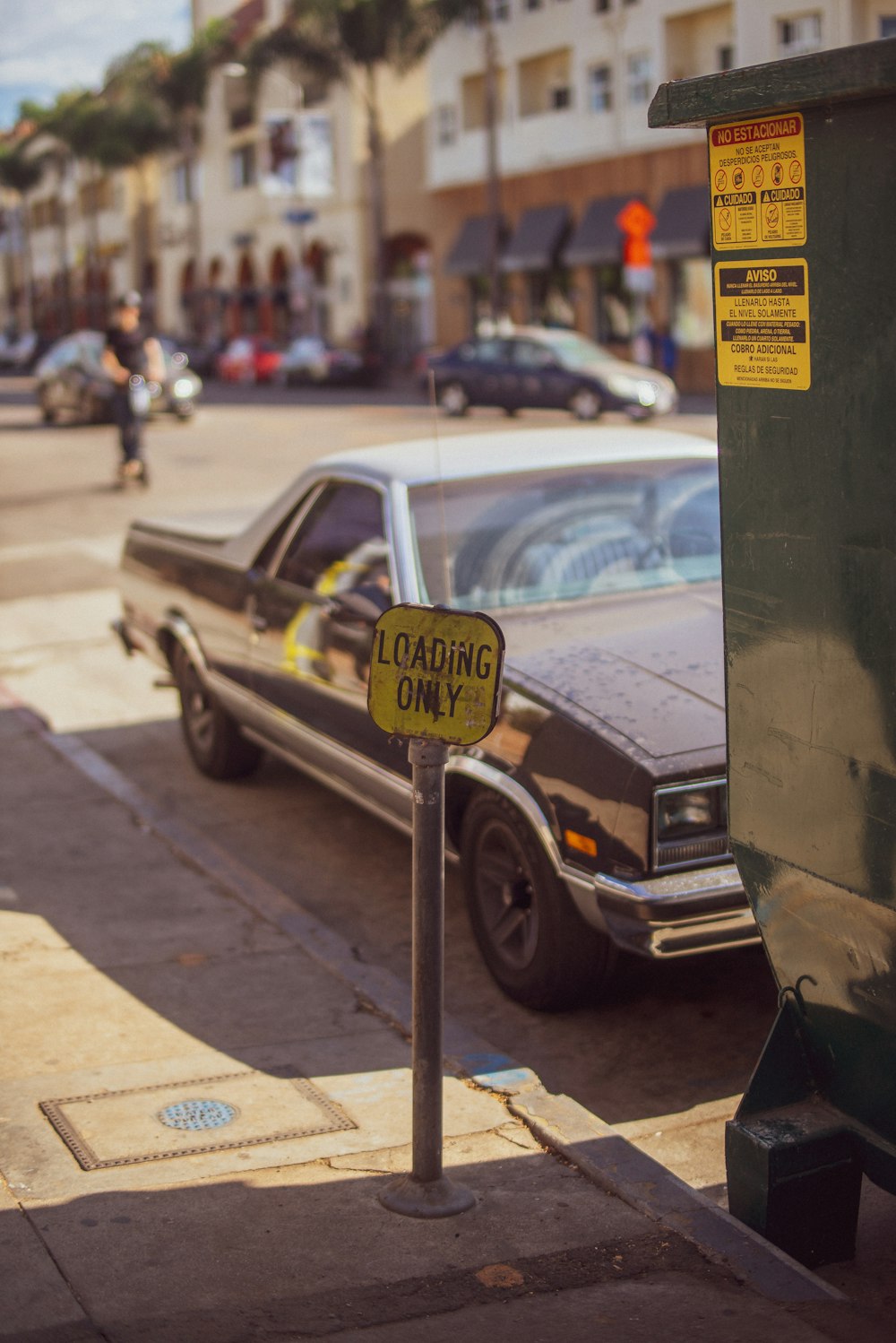 gray car parked beside yellow and black Loading Only street sign