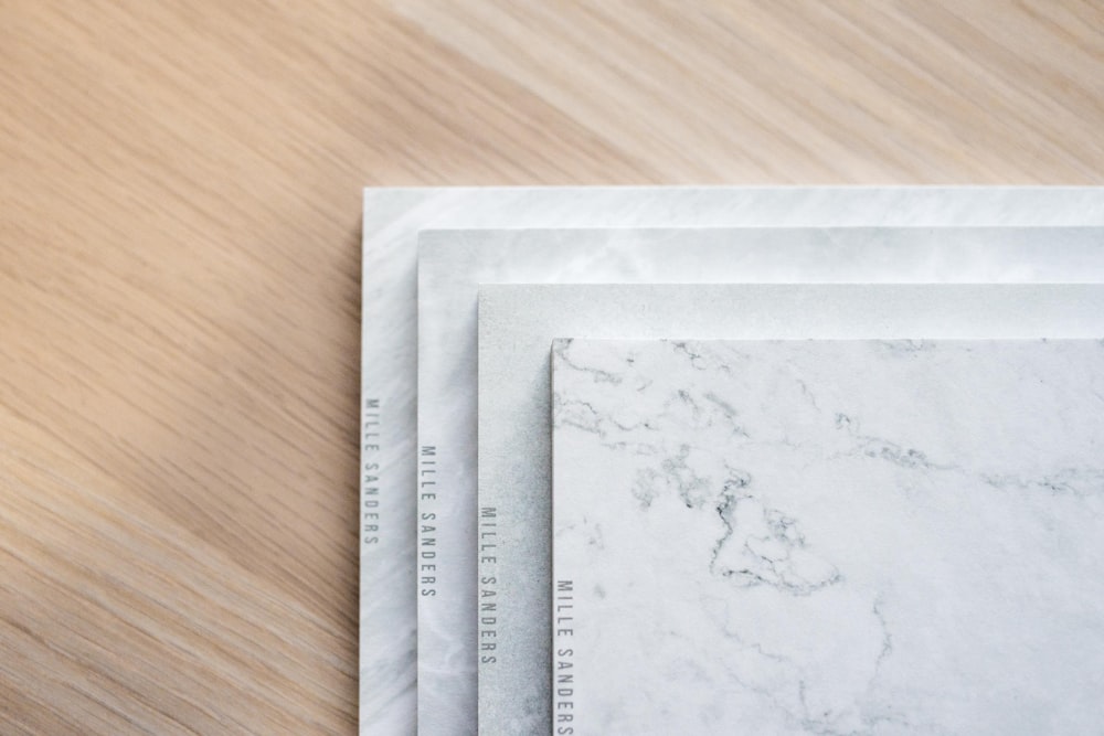 four white ceramic tiles on brown wooden surface