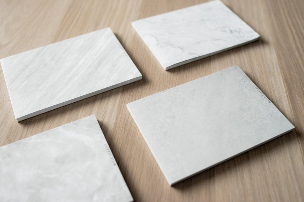 four white tiles on wooden surface