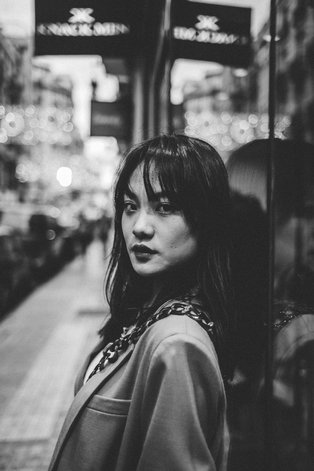 greyscale photography of woman near the building