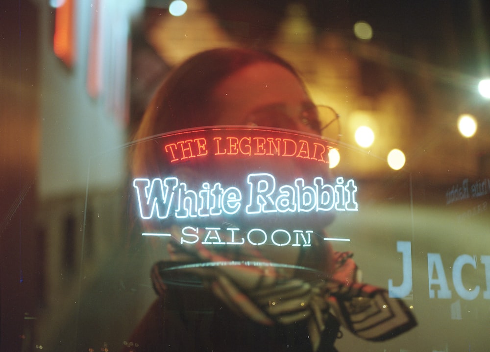reflection of White Rabbit Saloon signage from glass wall