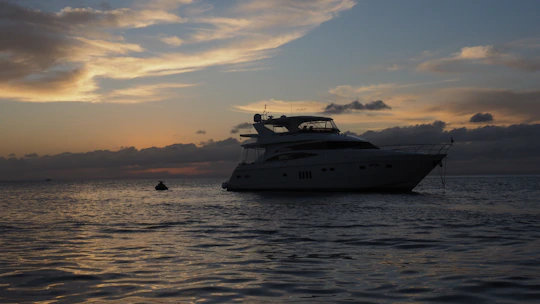 Sunset over a yacht anchored near the Dutch coast, with soft navy and gold hues in the sky.