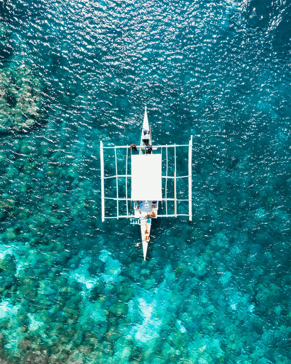 white and blue boat on the ocean photography