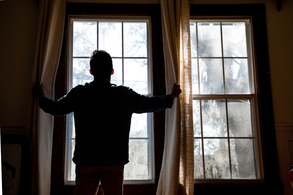 man holding yellow window curtain