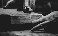 grayscale photography of person cutting slab