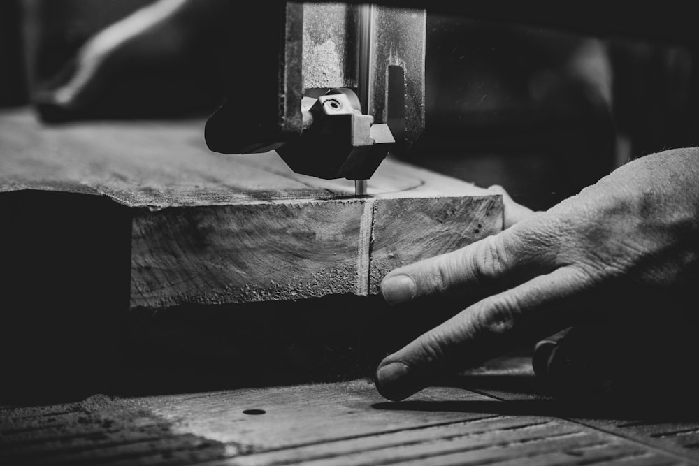 grayscale photography of person cutting slab