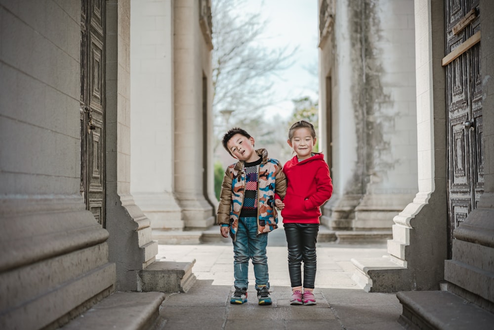 boy and girl standing in the middle of narrow pathway