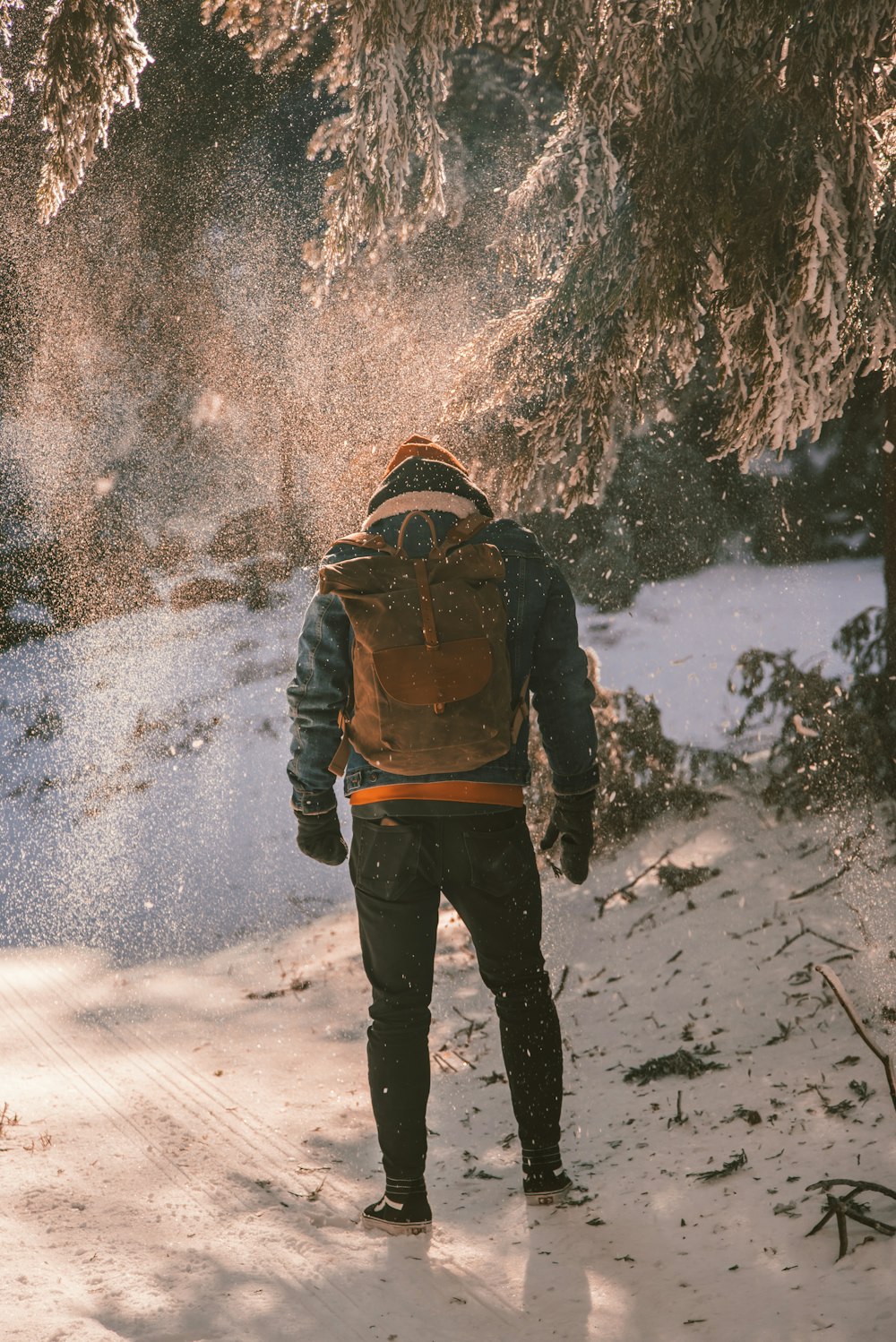 man walking along snowy mountain