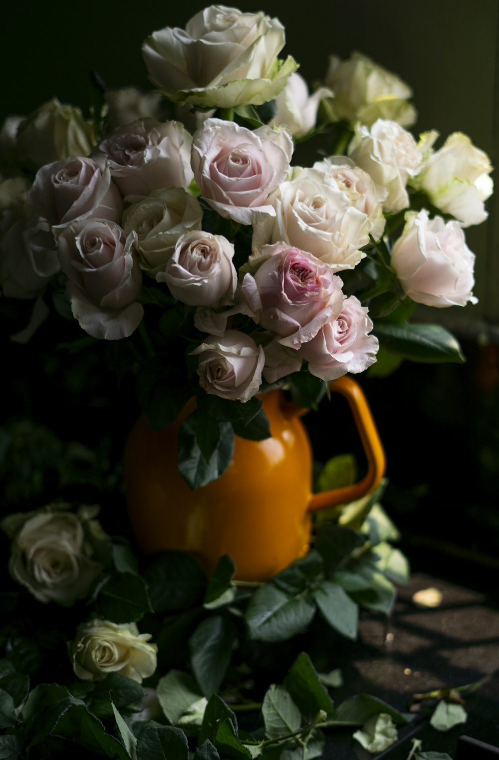 a bouquet of white and pink flowers on an orange pot