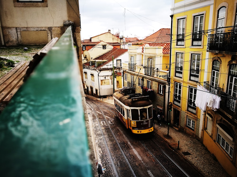 white and yellow train engine beside yellow building