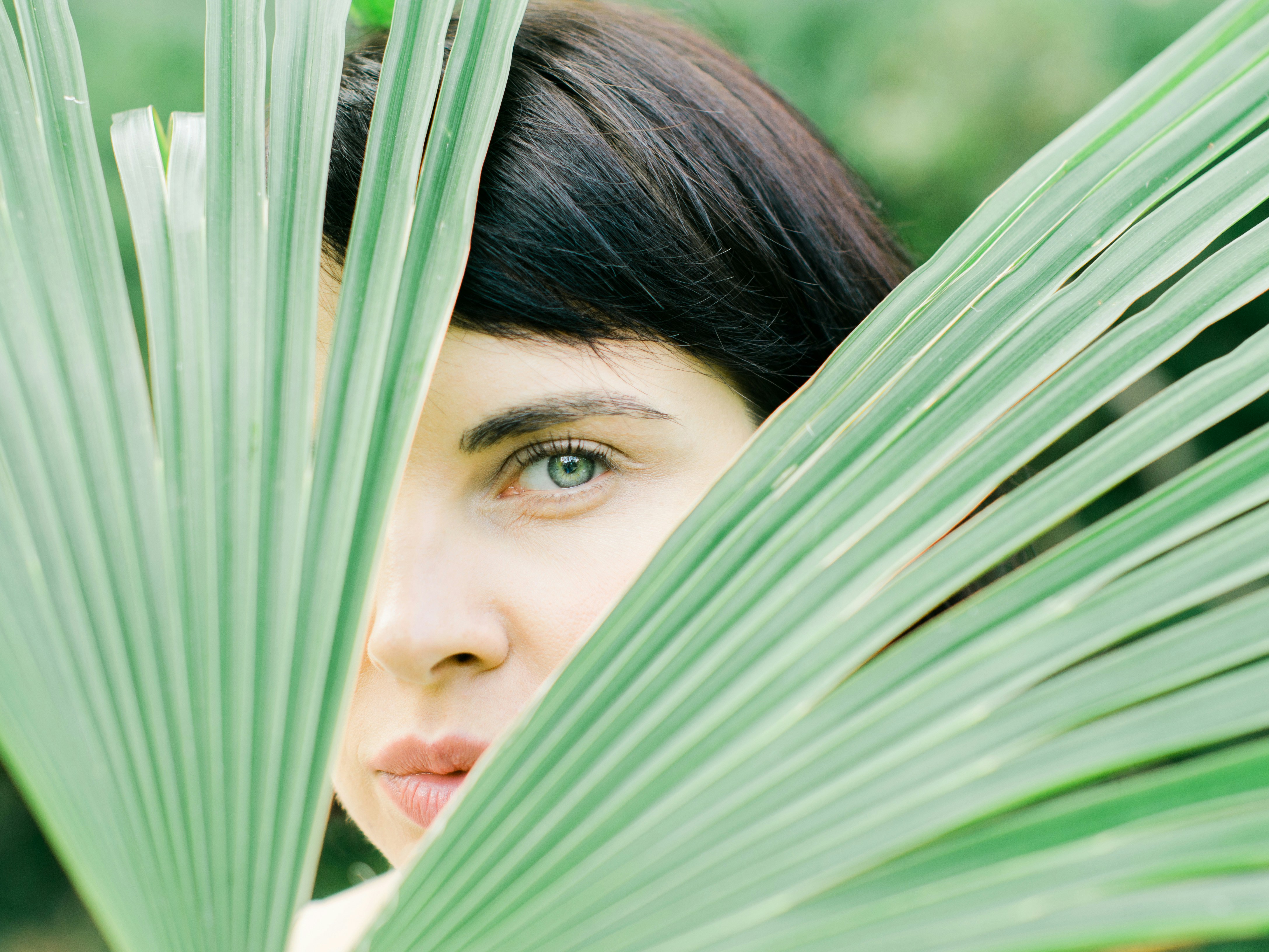 woman hiding behind fan palm