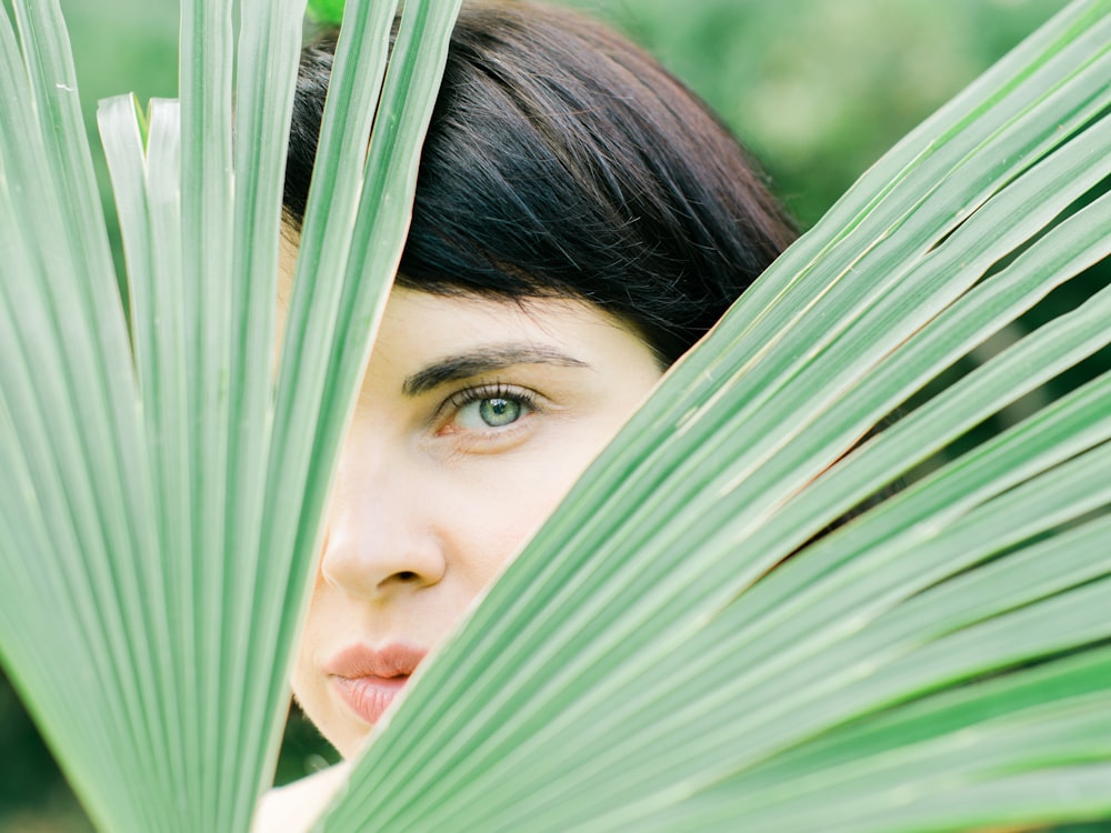 woman hiding behind fan palm