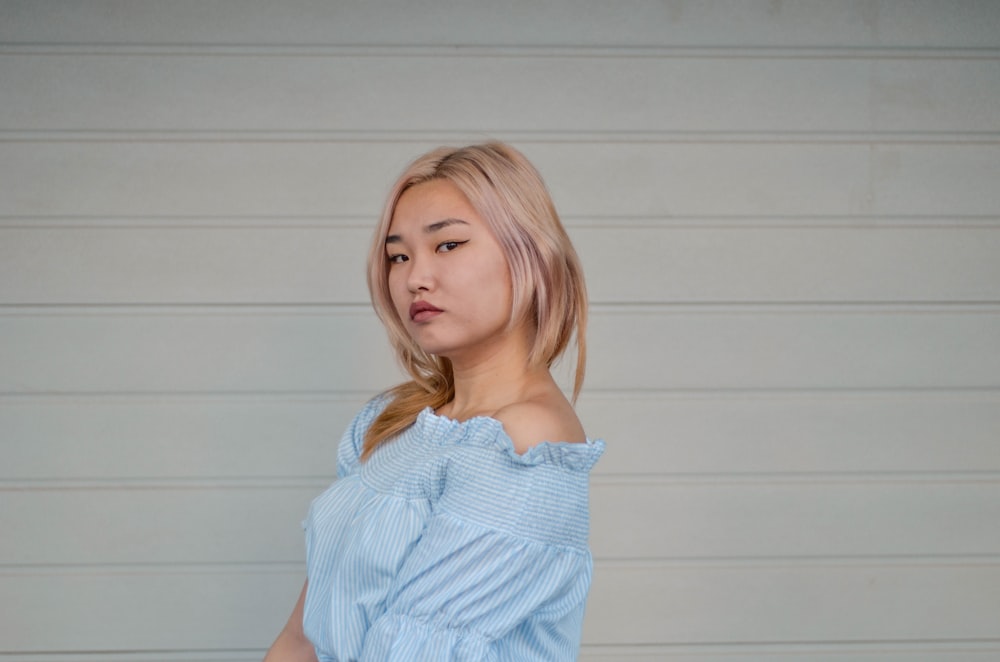 woman standing beside white wall