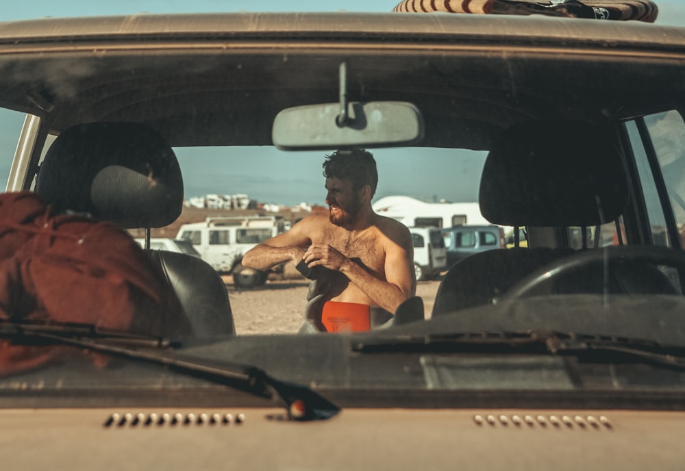 topless man behind vehicle