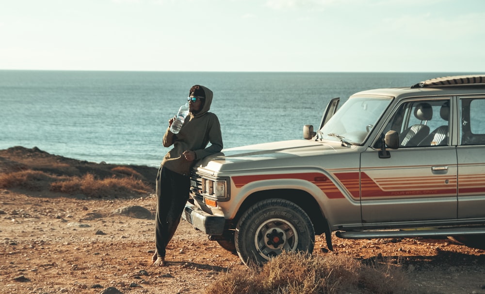 homem inclinado na frente do SUV