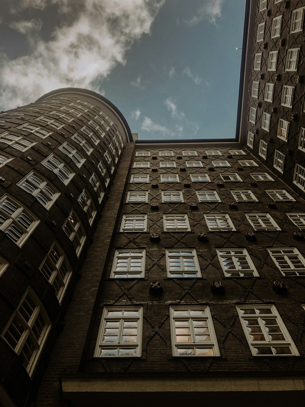 a tall building with windows and a sky background