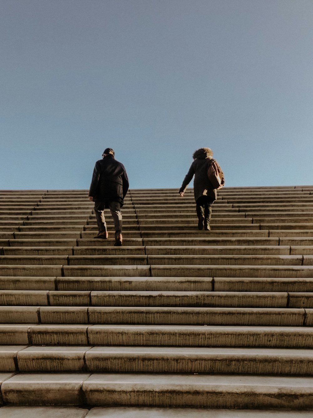 two persons walking up the stairs