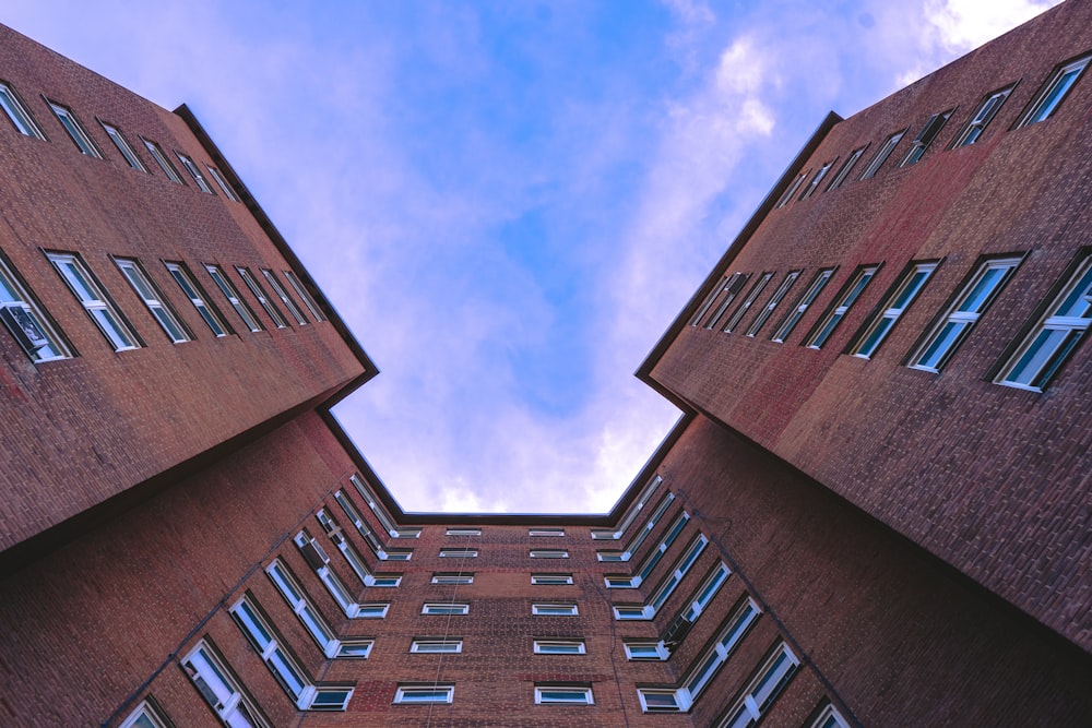 low-angle photography of maroon concrete multi-story building during daytime