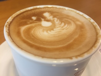Close-up of a latte art heart being poured into a ceramic cup on the mobile cart.