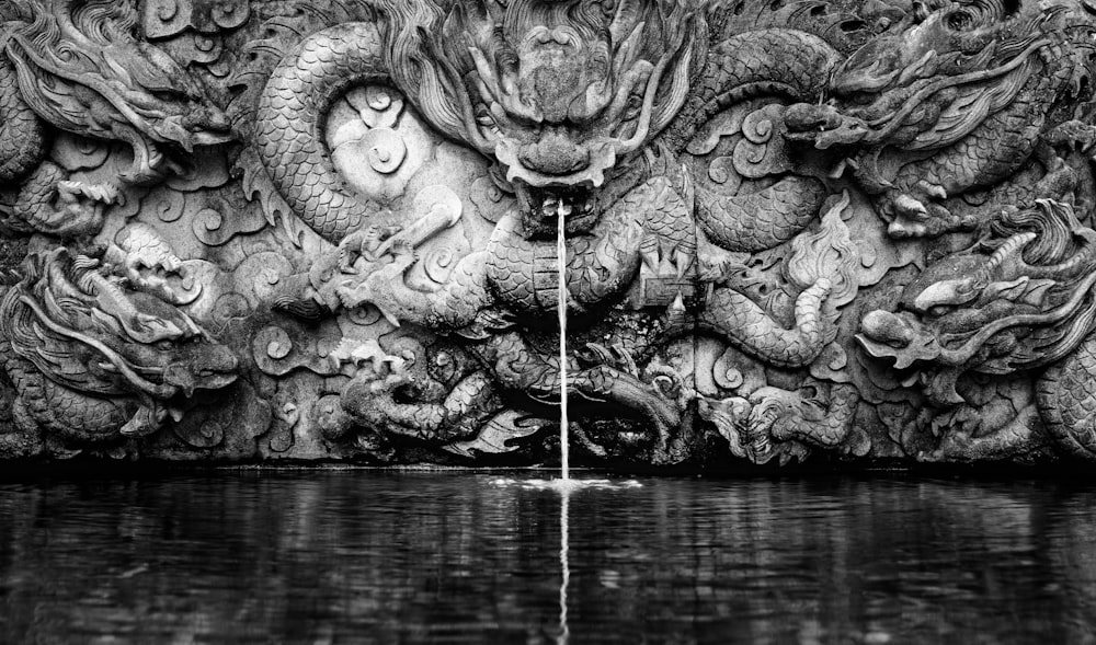 grayscale photography of dragon water fountain